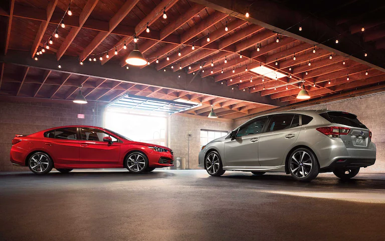 A photo of a 2022 Impreza 5-door and sedan parked in a garage.